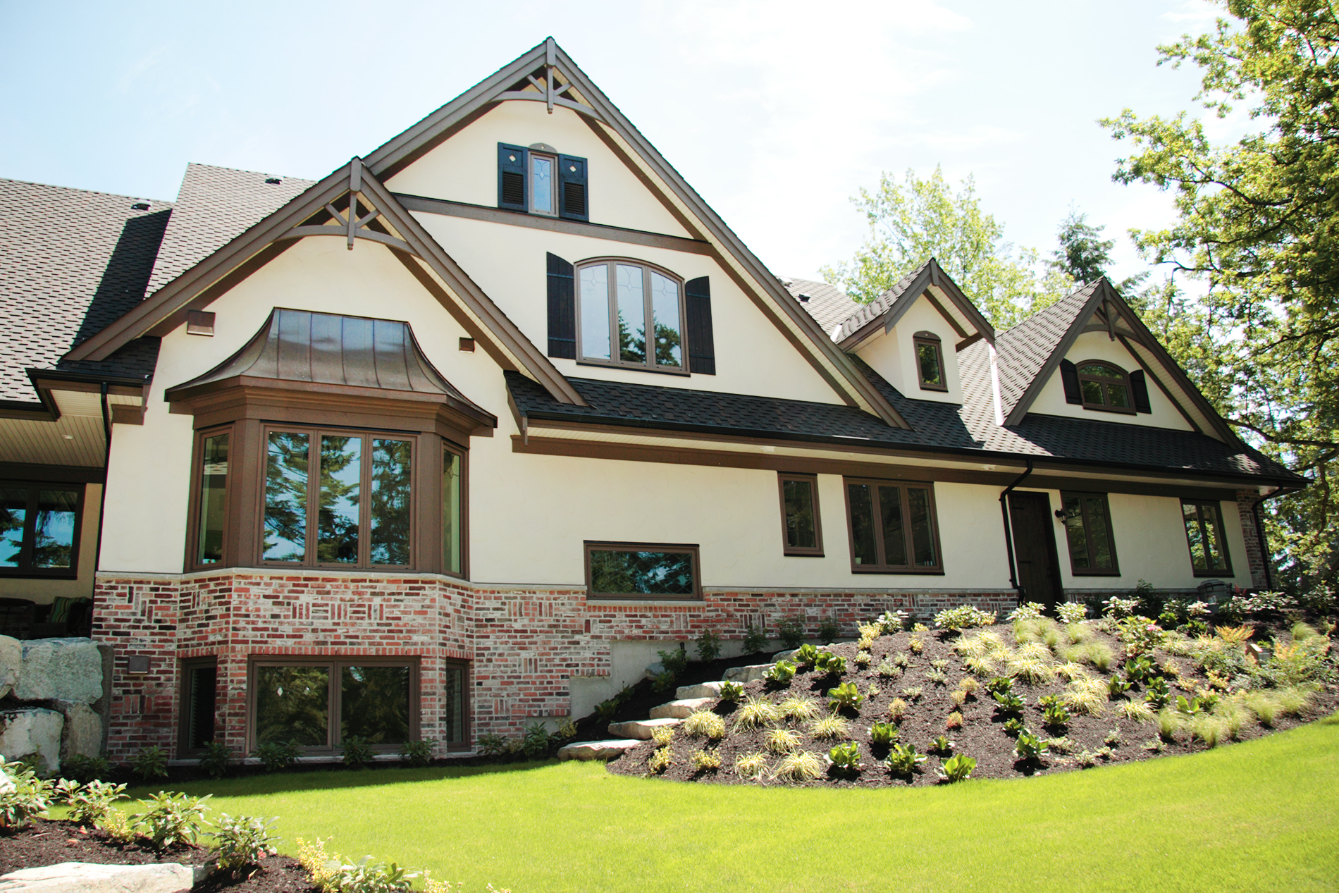 The front exterior view of a traditional style home with custom brown vinyl windows. 