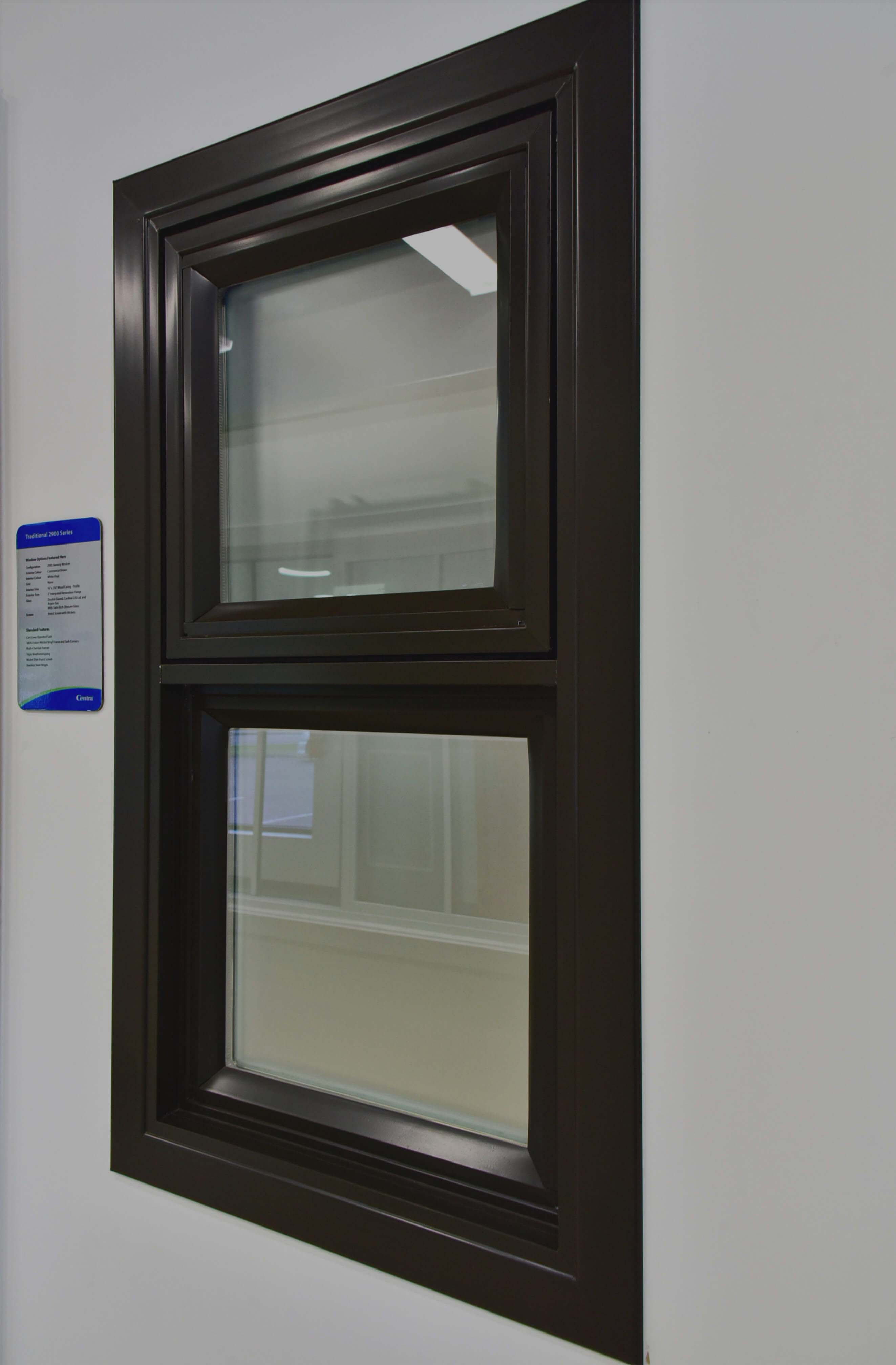 Black vinyl vertical sliding window manufactured by Centra with obscure glass for privacy.